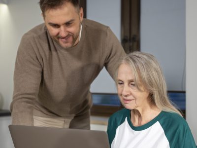 young-adult-teaching-elderly-person-about-degital-devicer